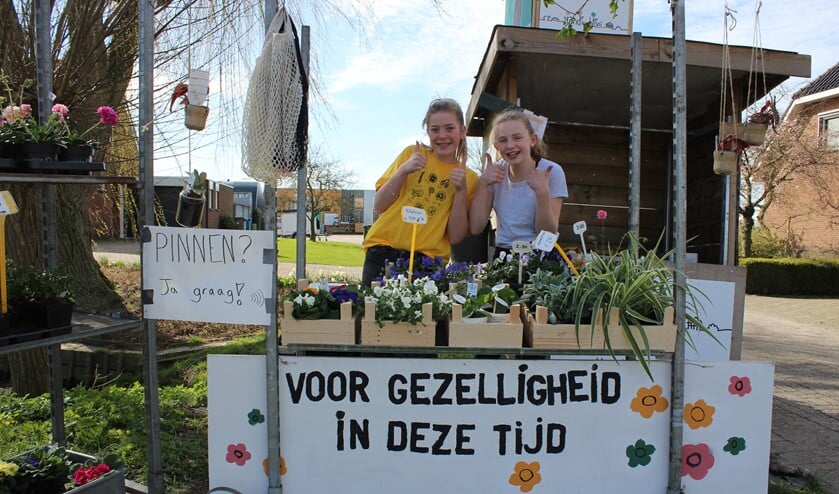 Ook Zorgkwekerij Bloei aan de Europalaan in Pijnacker blijft positief. Evie de Hoog en Julia Ammerlaan verkopen bloemige bakjes "gezelligheid". (foto: Martijn Mastenbroek)