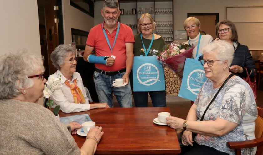 <p>Vrijwilligers van de catering en Ellen Tolhuisen (met bloemen) van Bewonersorganisatie Leidschenveen BOL met drie dames die gezellig koffiedrinken op de dag van de opening. Foto: Jan van Es</p>