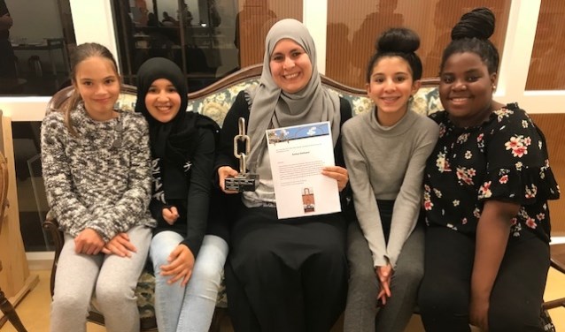 Asmaa Darkaoui met Dialoogaward te midden van brugklasleerlingen.