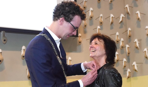 Locoburgemeester Martijn van der Putten speldt de onderscheiding bij Marieke Sieraad op. Foto: Hoedemaekers.