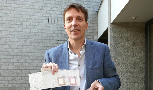 Erik van den Dungen toont een aantal persoonsbewijzen uit de collectie van het museum.