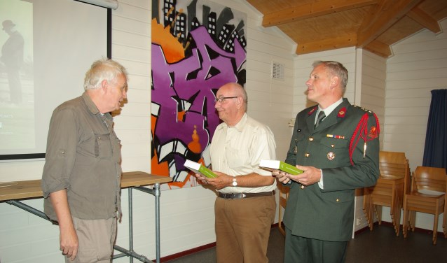 Hans Sakkers overhandigt de eerste twee boeken.