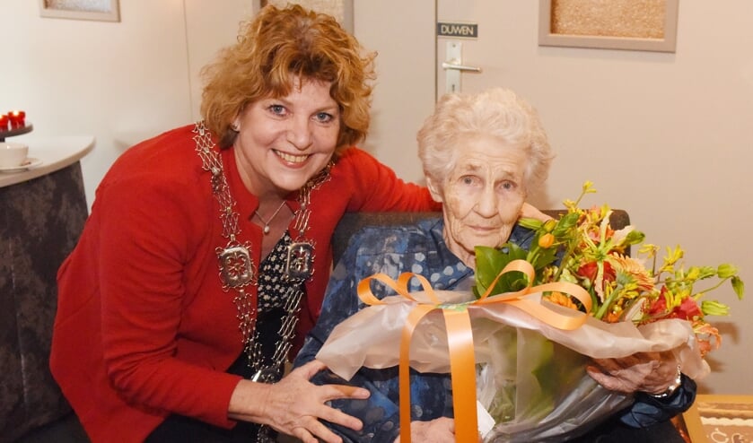 Carla Brugman zet de 100-jarige mevrouw Veldpaus-Thijssen in de bloemetjes.