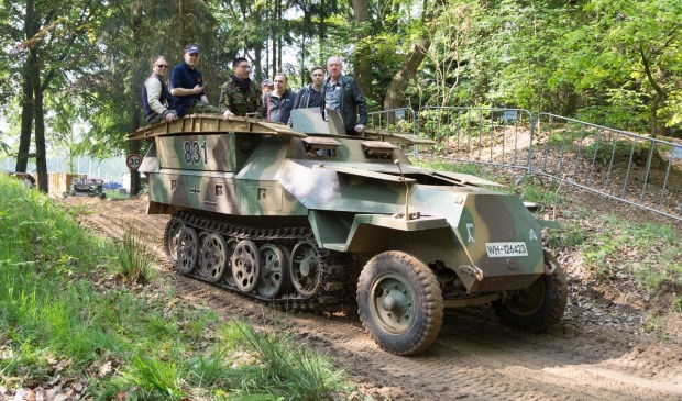 Een groepje bezoekers rijdt mee in een van de vele militaire voertuigen tijdens Militracks.