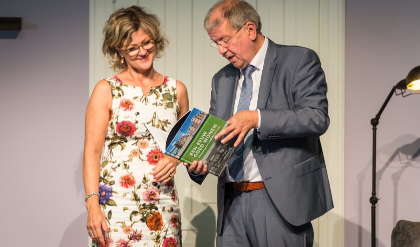 Vertrekkend directeur-bestuurder Simon van Nieuwaal overhandigd het 'Een eeuw goed wonen' aan burgemeester Grootenboer.