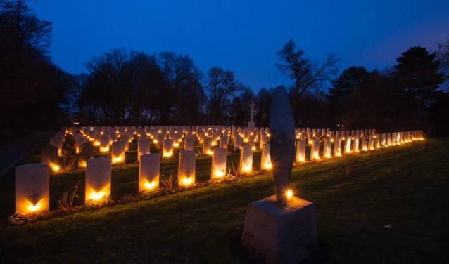 Aangestoken lichtjes bij oorlogsgraven.