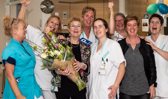 De vertrekkende Han Brinkman met enkele van haar collega's, die haar maar wat graag in het zonnetje zetten.
