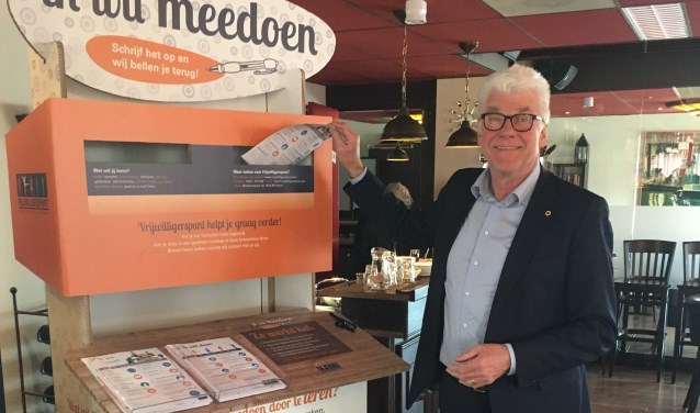 Wethouder Dorus Luyckx van Enkhuizen post het eerste aanmeldformulier in de kleurrijke brievenbus.