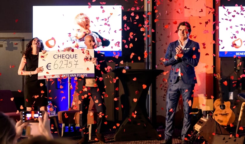 Presentator Toine van Peperstraten en de ouders van Valenti, Roxanne en Dimitri Kalaitzis, met de cheque.