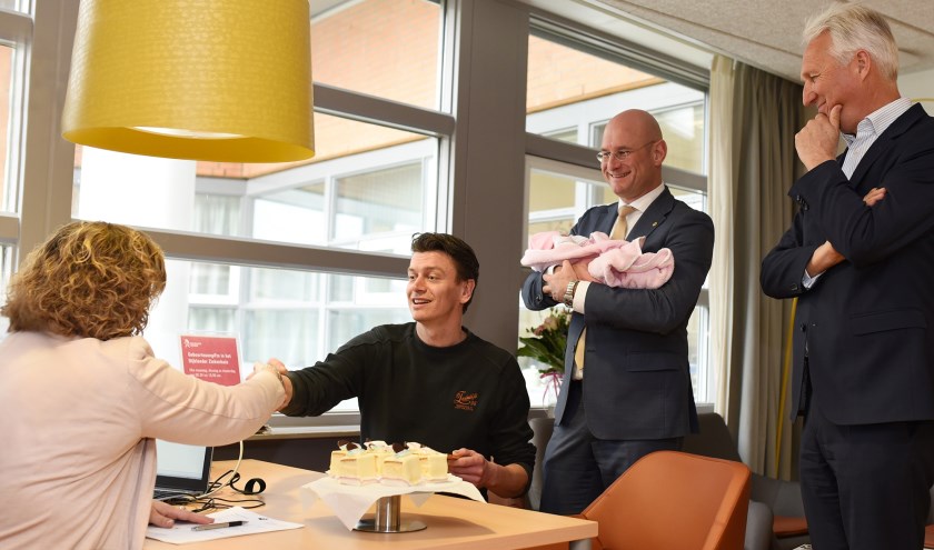 Robert Jan Slob (l) doet aangifte van zijn pasgeboren dochter Maud. Rechts van hem staat burgemeester Jan Nieuwenburg met Maud in zijn armen. Daarnaast Arno Timmermans.