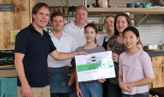Het personeel van de BioExpress reikt de prijs uit aan Team Sushi-burger.