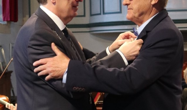 Het lintje wordt opgespeld door de burgemeester.