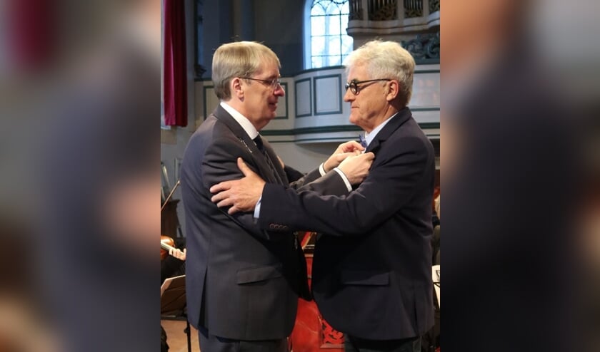 Het lintje wordt opgespeld door de burgemeester.