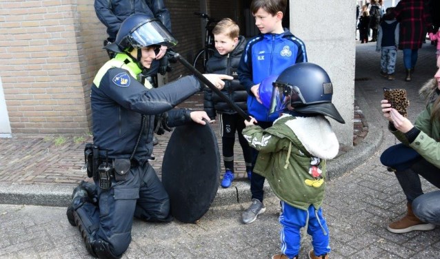 Deze politieman legt de jongste jeugd iets uit.