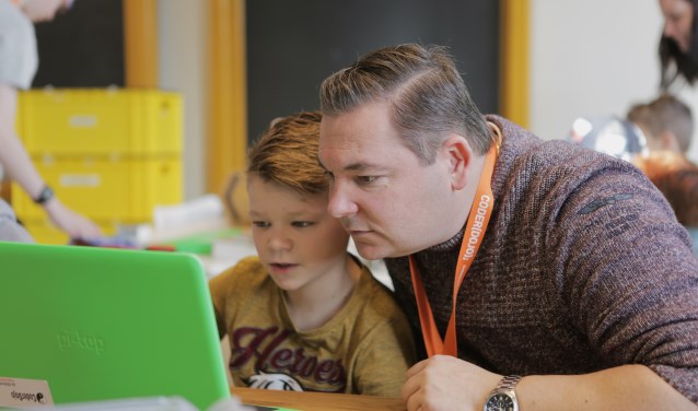 Kinderen leren programmeren onder leiding van vrijwilligers in de Coderdojo.
