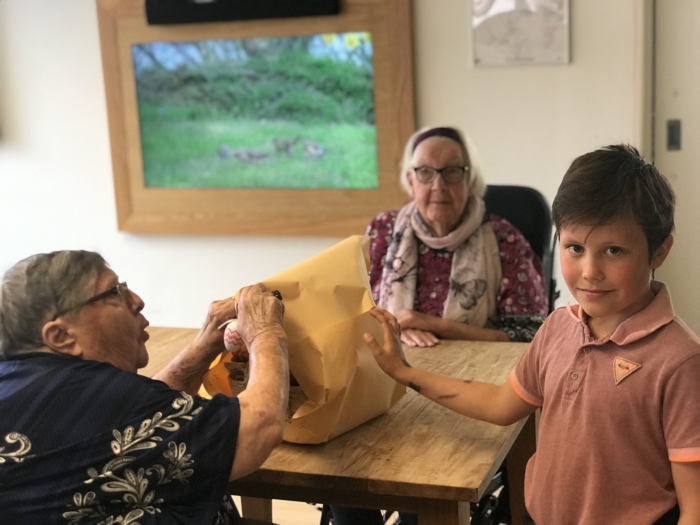 Abel uit groep 5 geeft een van de Paasmanden aan bewoners van Oudtburgh