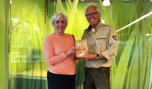 Auteur Cockie Vlietman overhandigt het eerste boek aan een boswachter.