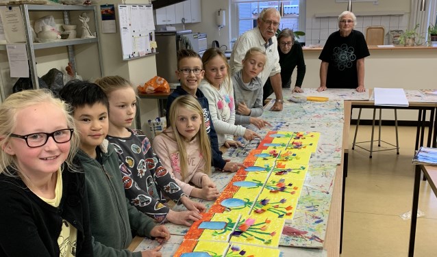 De kinderclub van de KsK'80 met hun eigen voorjaarskunstwerkjes. Met op de achtergrond drie enthousiaste docenten.
