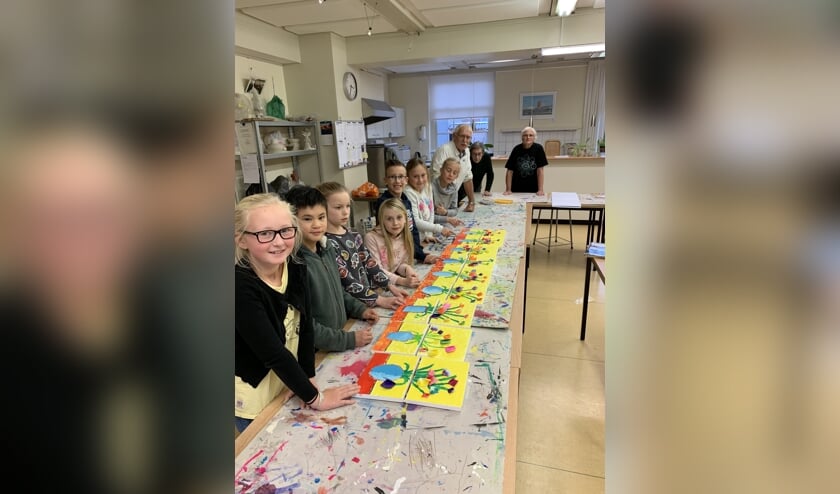 De kinderclub van de KsK'80 met hun eigen voorjaarskunstwerkjes. Met op de achtergrond drie enthousiaste docenten.
