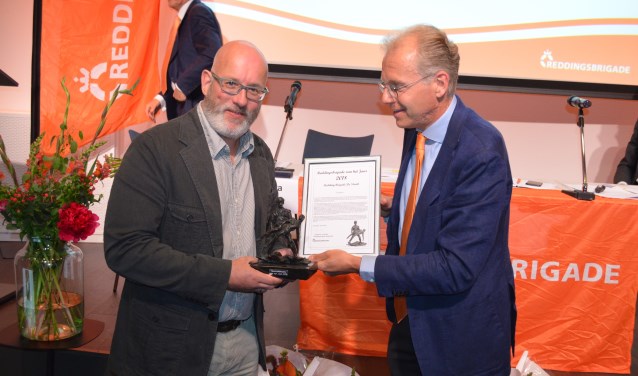Voorzitter Bob Koelman neemt de trofee Reddingsbrigade van het Jaar in ontvangst.