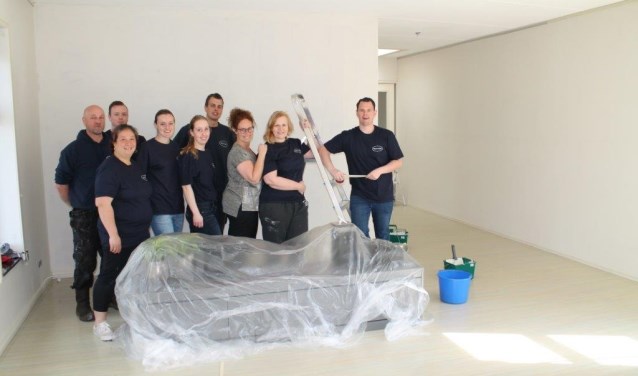 'Na het klaren van de klus met z'n allen op de foto in de verfriste woonkamer. Derde van rechts Marieke Zwart, coördinator van het hospice.