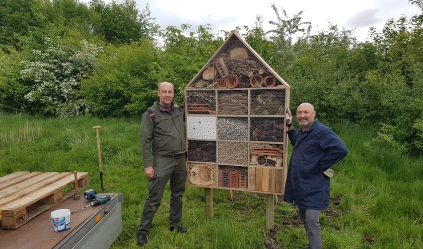 Boswachter Paul Bot (l) en onderwijsassistent Babis Saridakis begeleiden de scholieren bij het maken van de bijenhotels.