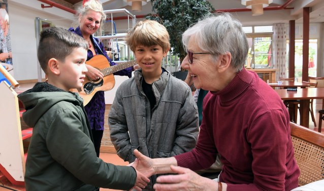 Six en Joah met een mantelzorgster, op de achtergrond zangjuf Jessica van Noord.