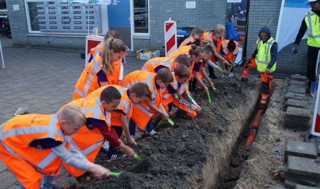 Leerlingen van De Hasselbraam mochten het zand weer terug de geul in scheppen.
