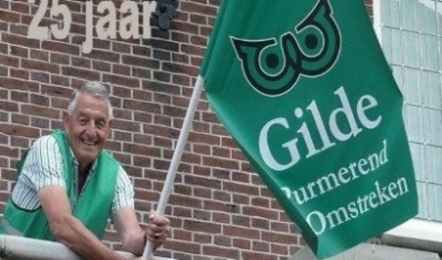 Voorzitter Dick Blokker van Gilde Purmerend en Omstreken hijst de vlag op het oude stadhuis.