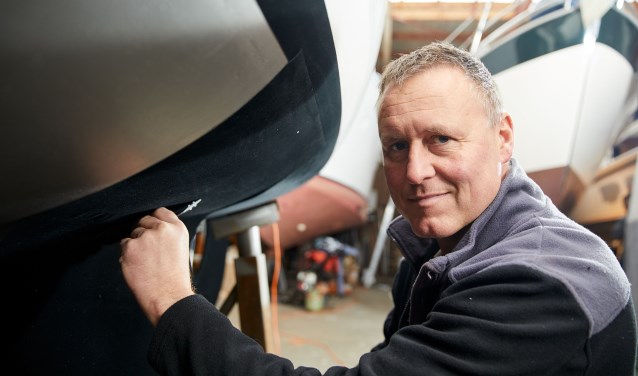 Rik Breur plakt het door hem uitgevonden zelfklevend antifouling ‘tapijt’ op een boot.