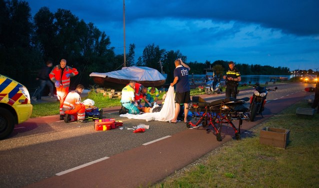 Ter plaatse heeft de gewonde motorrijder alle zorg nodig van het ambulancepersoneel.