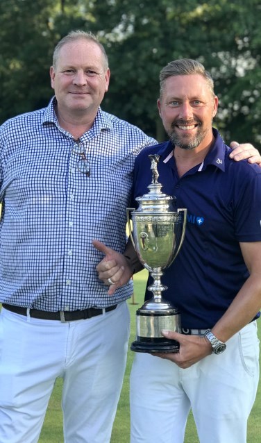 Mark Reynolds (r) heeft de trofee van het PGA Kampioenschap ontvangen van PGA Holland-directeur Frank Kirsten.
