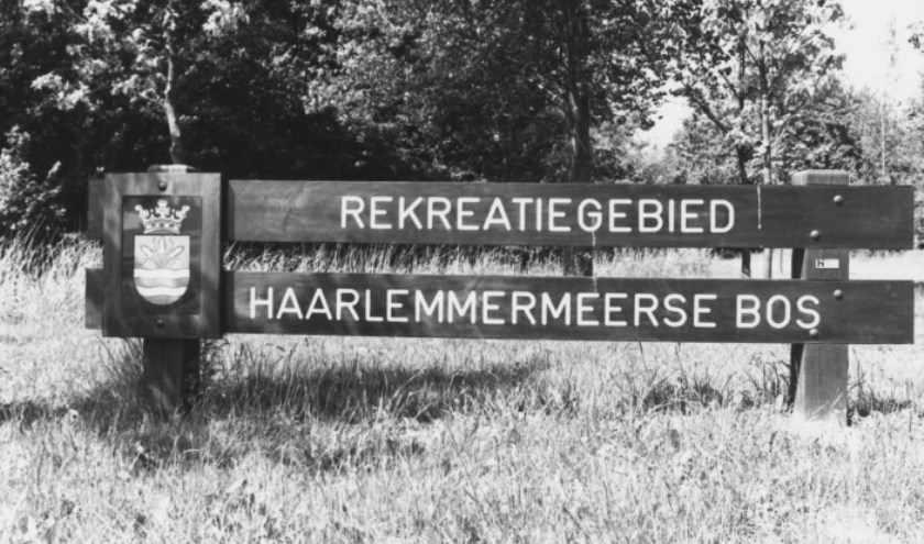 Houten bord bij de ingang van het bos.