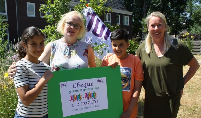 DURV! leerlingen Aya en Sani overhandigen de cheque aan Cretienne Hoekman van speeltuin OKB.