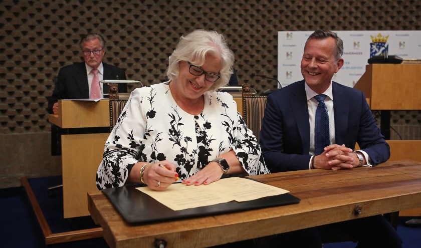 Marianne Schuurmans tekent dé papieren, onder toeziend oog van Commissaris van de Koning, Arthur van Dijk.