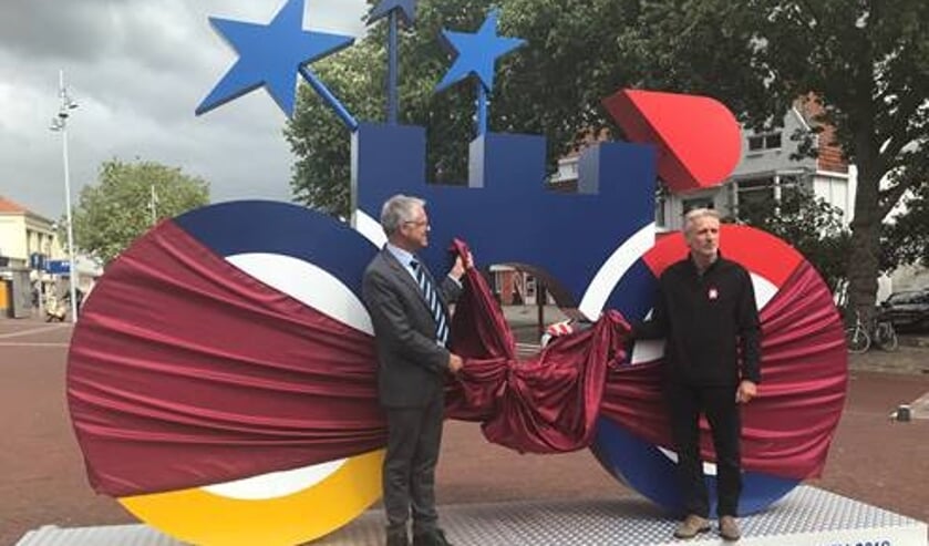 Wethouder Pieter Dijkman en Vincent Thijssen onthullen deze supergrote fiets op station Alkmaar.