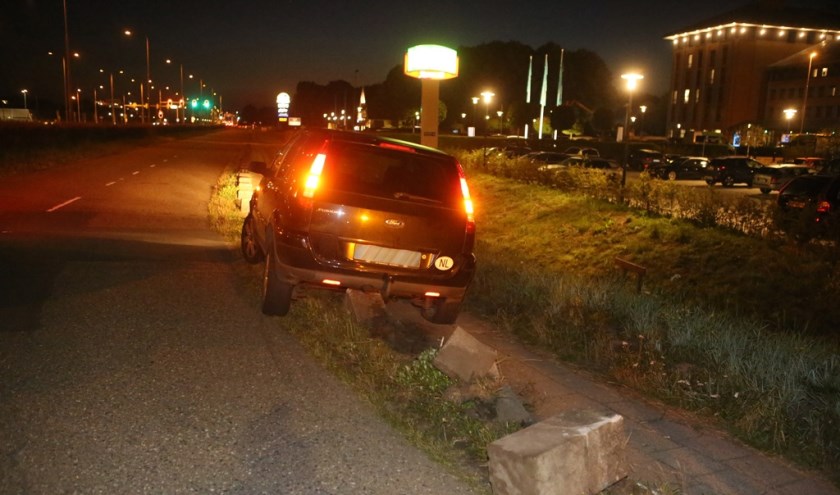 Hoe de vrouw op de betonblokken terechtkwam, is niet duidelijk, maar haar auto moest er af getakeld worden.