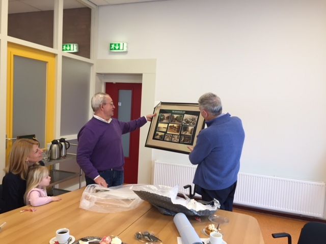 Een schilderij met prenten uit de privécollectie van Nico Boerma wordt overhandigd aan Henk van Breemen. (Foto: aangeleverd)