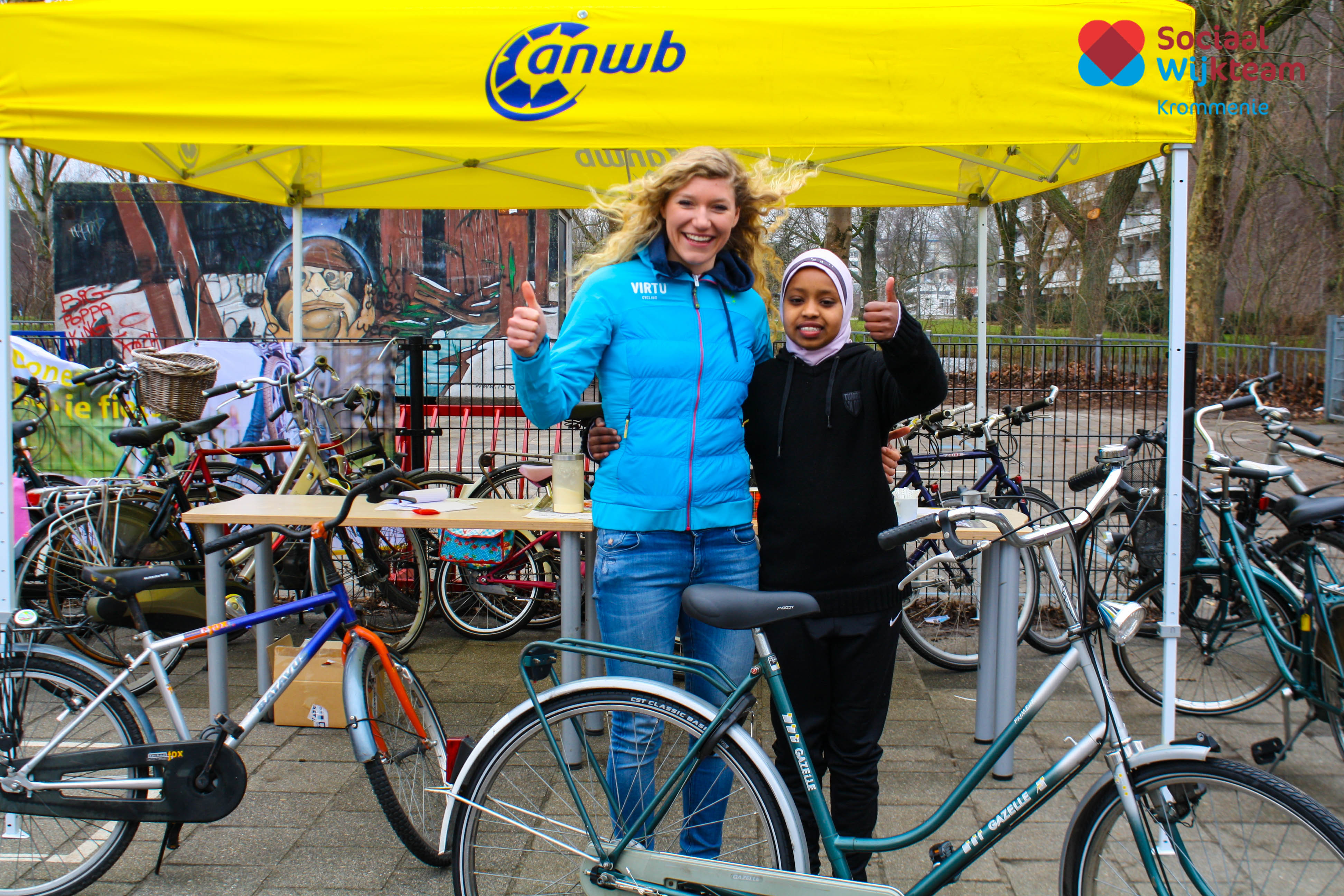 Professioneel wielrenster Claudia Koster met één van de kinderen die een fiets ontvangt vanuit het Kinderfietsenplan van de ANWB. (Foto: swtzaanstad)