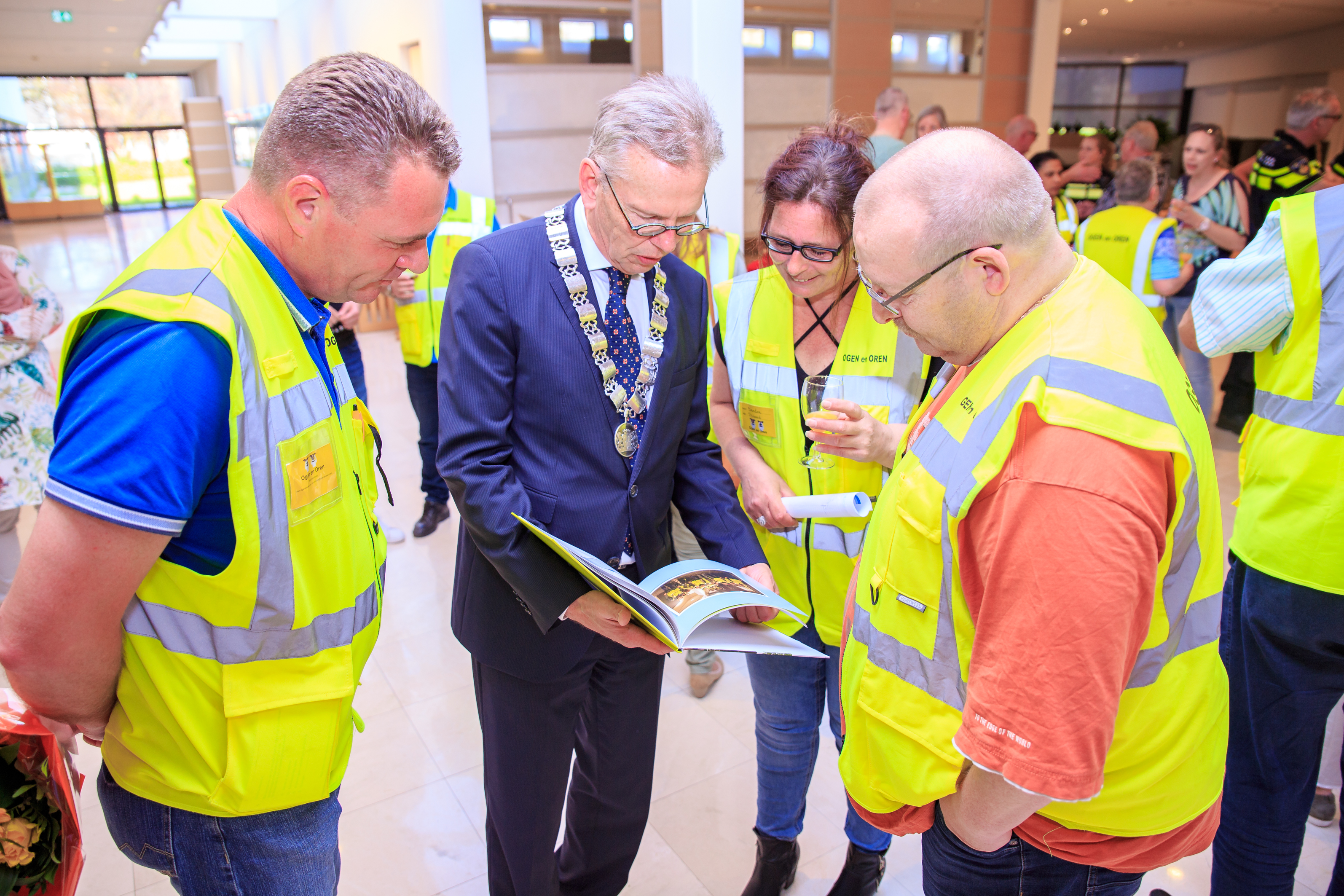 Coen Lageveen, een van de coördinatoren van Ogen en Oren, overhandigde het eerste jubileumboekje aan de burgemeester. (Foto: Gemeente Purmerend)
