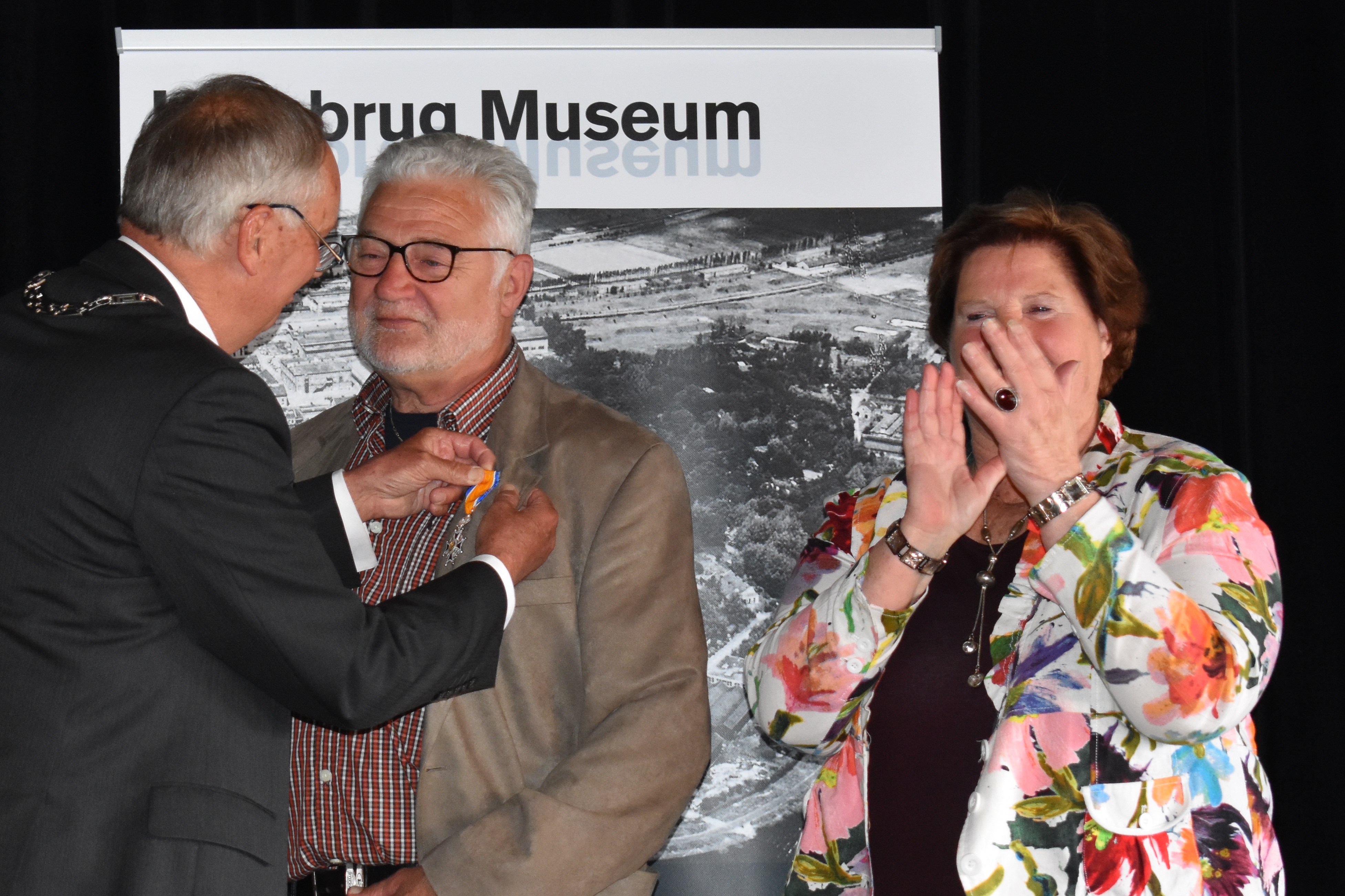 Burgemeester Rob Posthumus speldt Peter de Vries zijn penning op. Zijn vrouw kijkt verrast toe. (Foto: Daan Ruijter/Rodi Media)