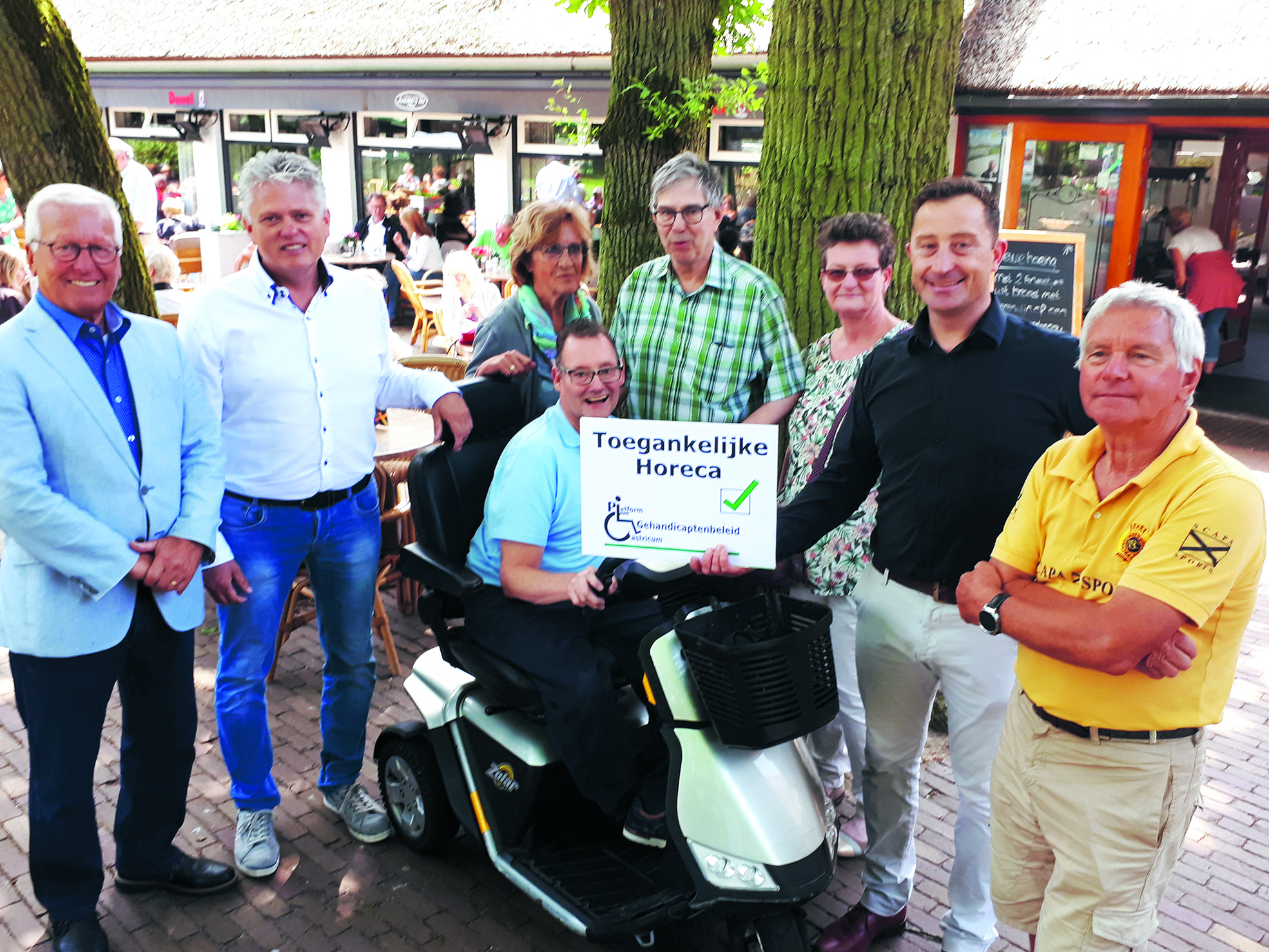 Wethouder Swart (l) en naast hem Edwin Steeman hebben het keurmerk overhandigd aan Theo Groentjes (tweede van rechts) temidden van de andere leden van het Platform Gehandicaptenbeleid. (foto aangeleverd)
