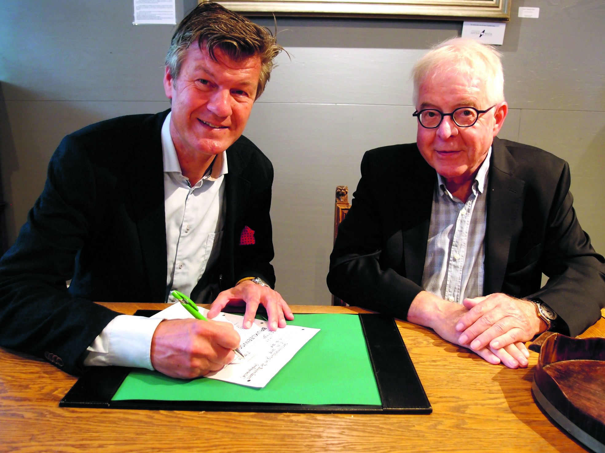 Burgemeester Mans en Peter Sibinga ondertekenen de ingebruikgeving van het antieke raadsmeubilair.(foto Hans Boot)