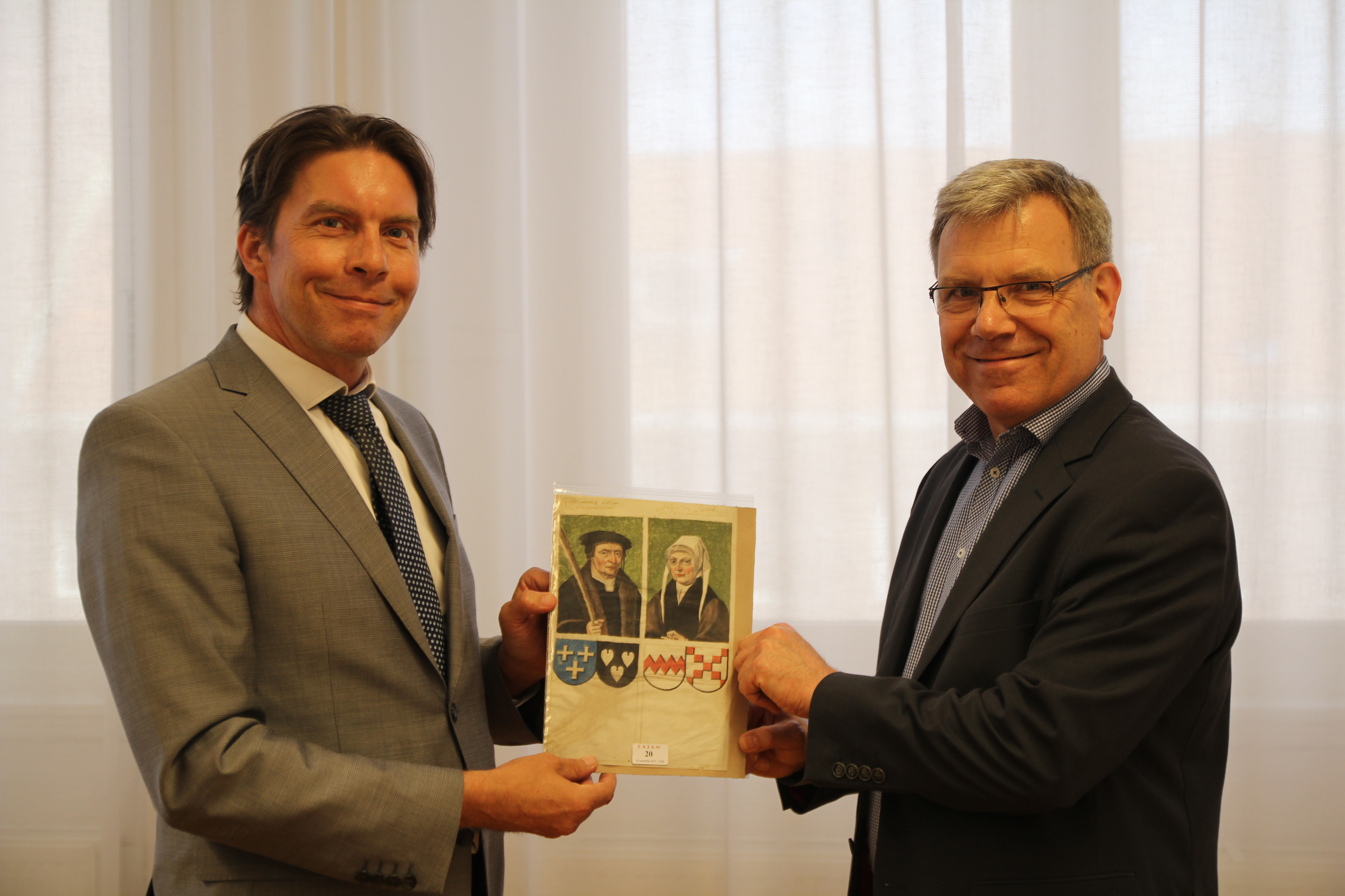 Jonkheer dr. Pieter W. van Foreest (links) draagt het blad met de portretten over aan directeur Paul Post van het Regionaal Archief