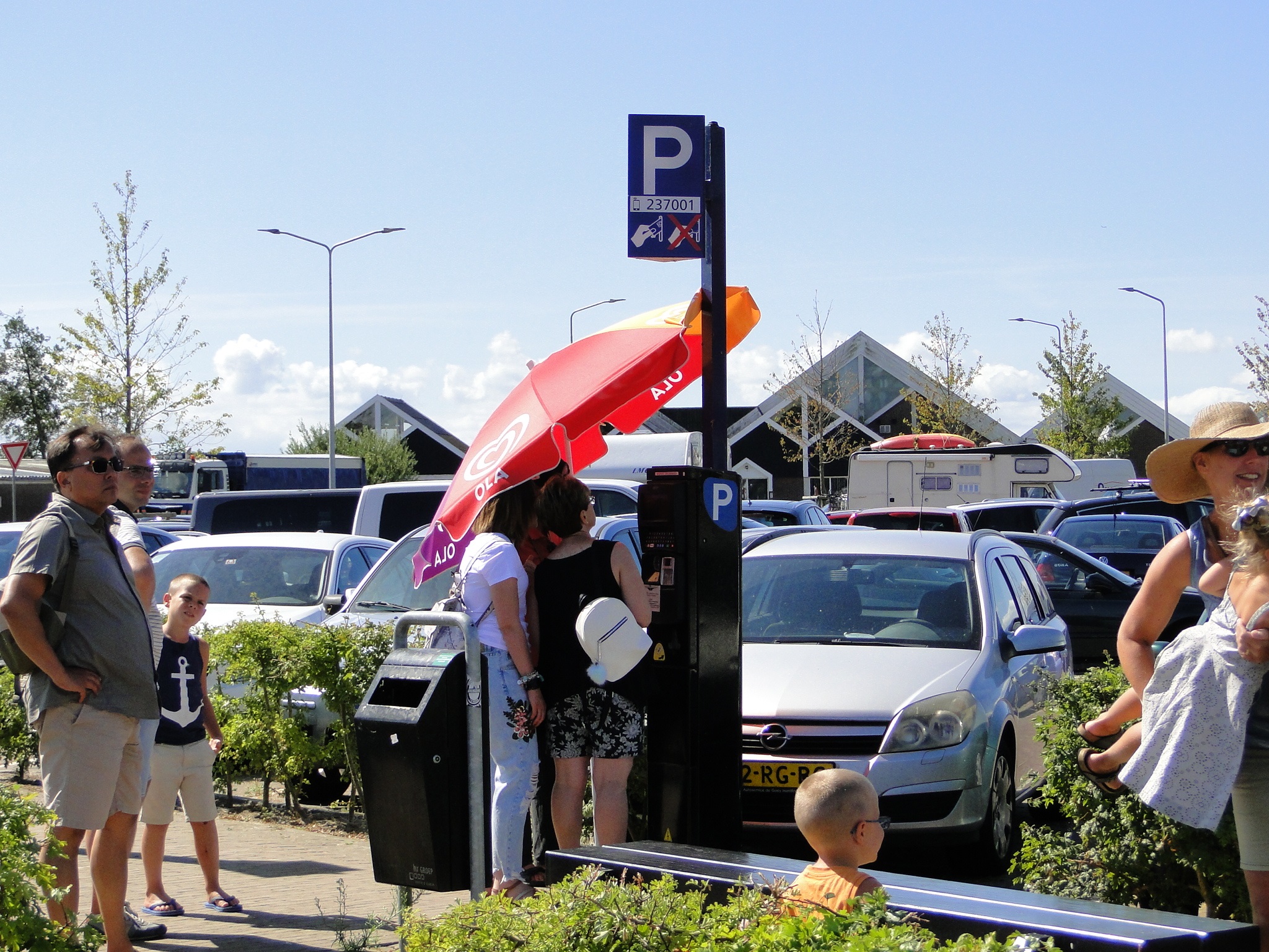 Met het extreem warme weer van de afgelopen dagen hebben ook de parkeerautomaten een parasol nodig voor wat verkoeling. (Foto: Pep)
