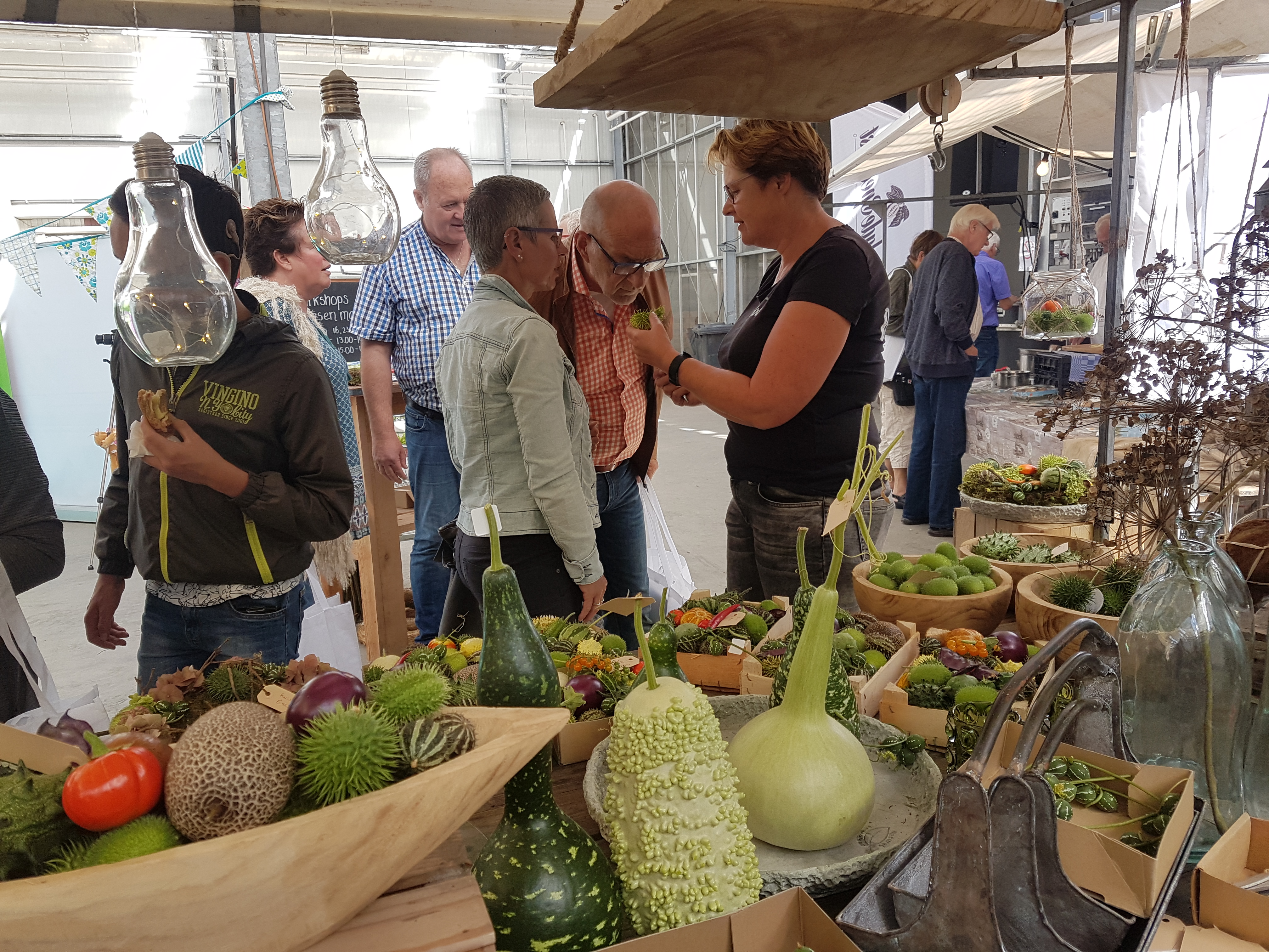 Afke Schrale van Bloeiers geeft uitleg over haar siervruchten op de Boerenversmarkt. (Foto: aangeleverd)