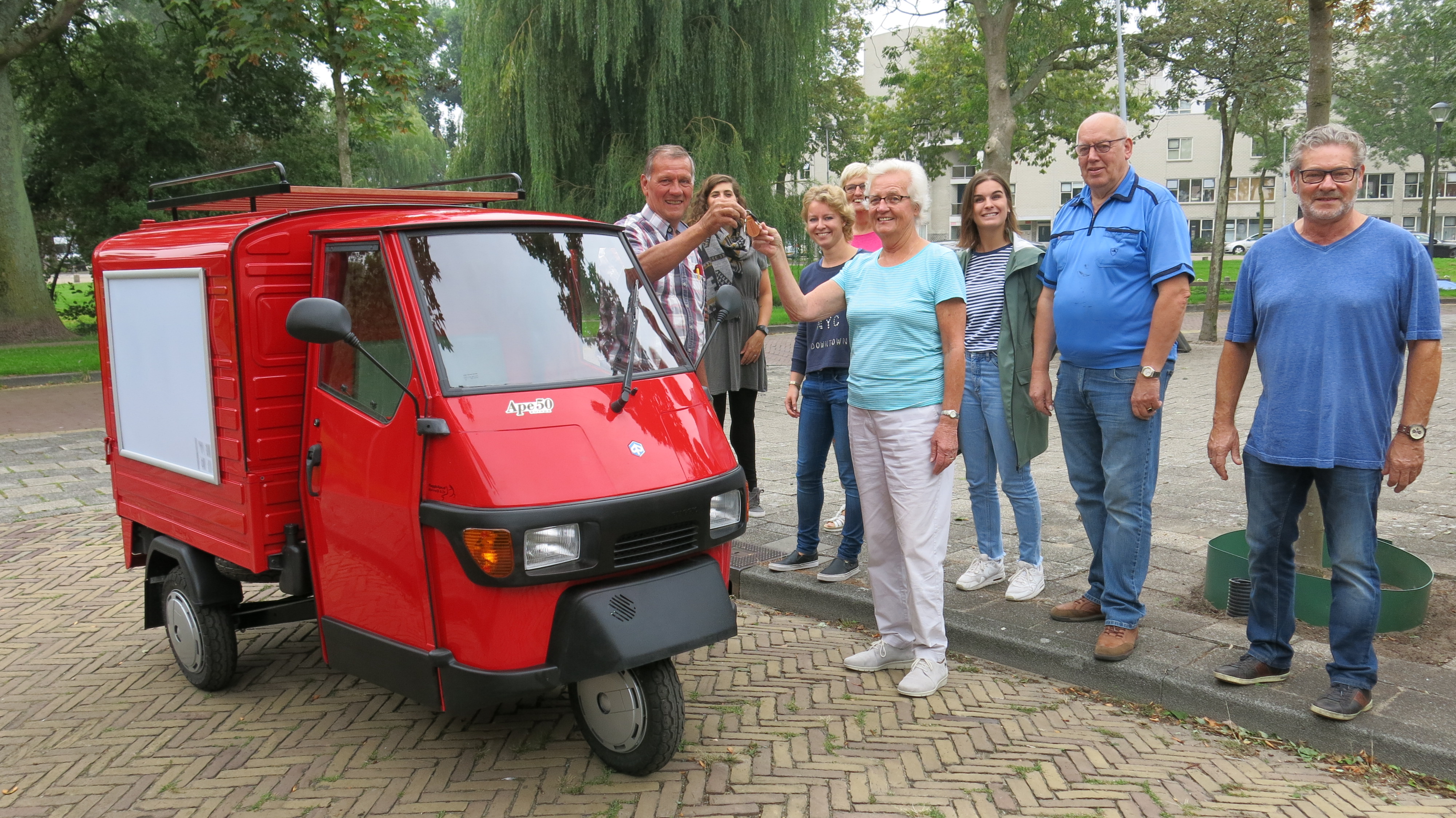 De voorzitter van de Diaconie van de Protestantse Gemeente Haarlem, Immy Nieboer, krijgt de sleutel overhandigd van Vakgarage Van Marrewijk (TukTukFabriek). (Foto: Margriet Van Tilborg)