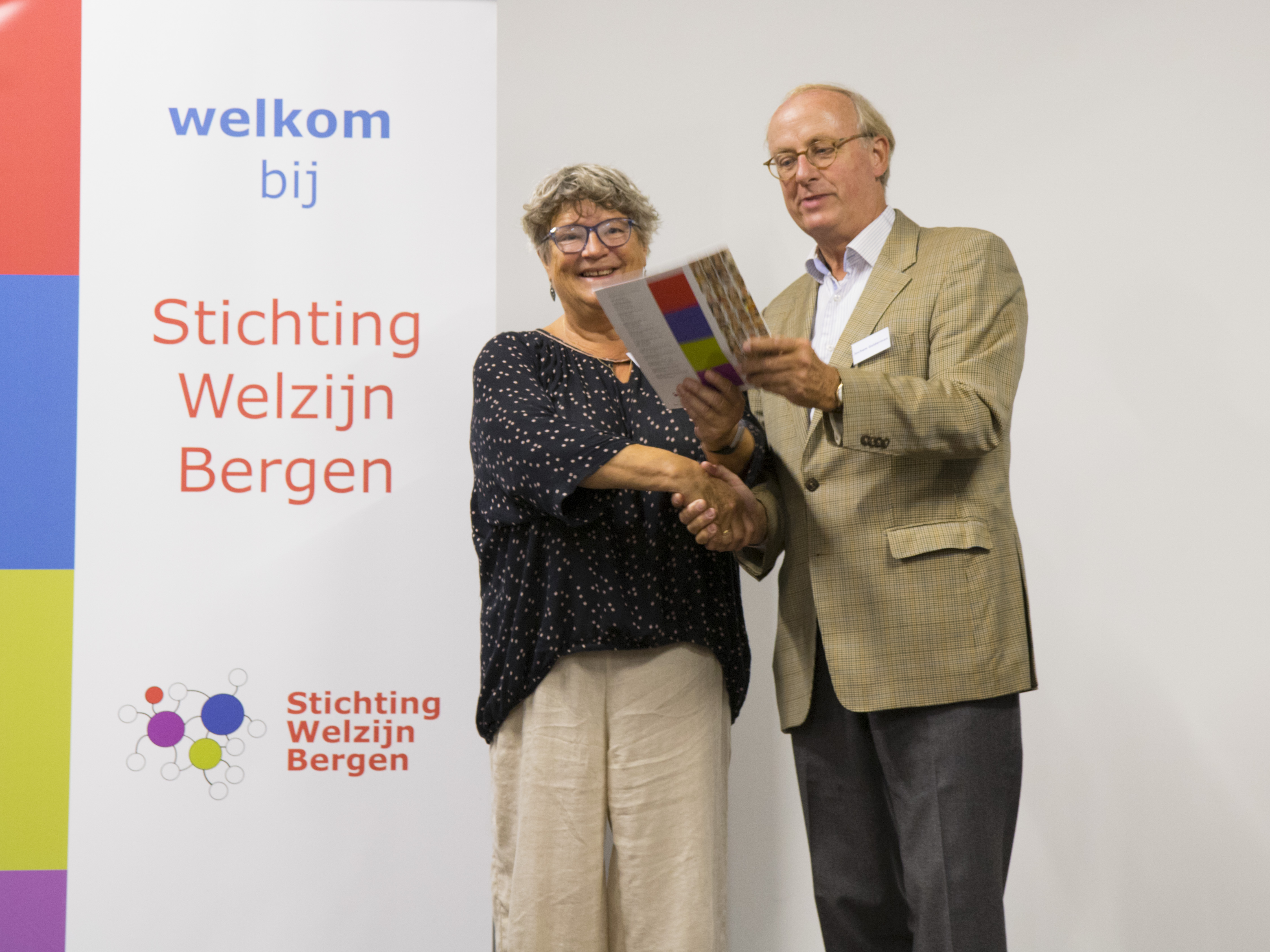 Renske de Vreede ontving het eerste exemplaar 'Wij zijn' van Stichting Welzijn Bergen uit handen van Jochem Gelderman. (Foto: aangeleverd).