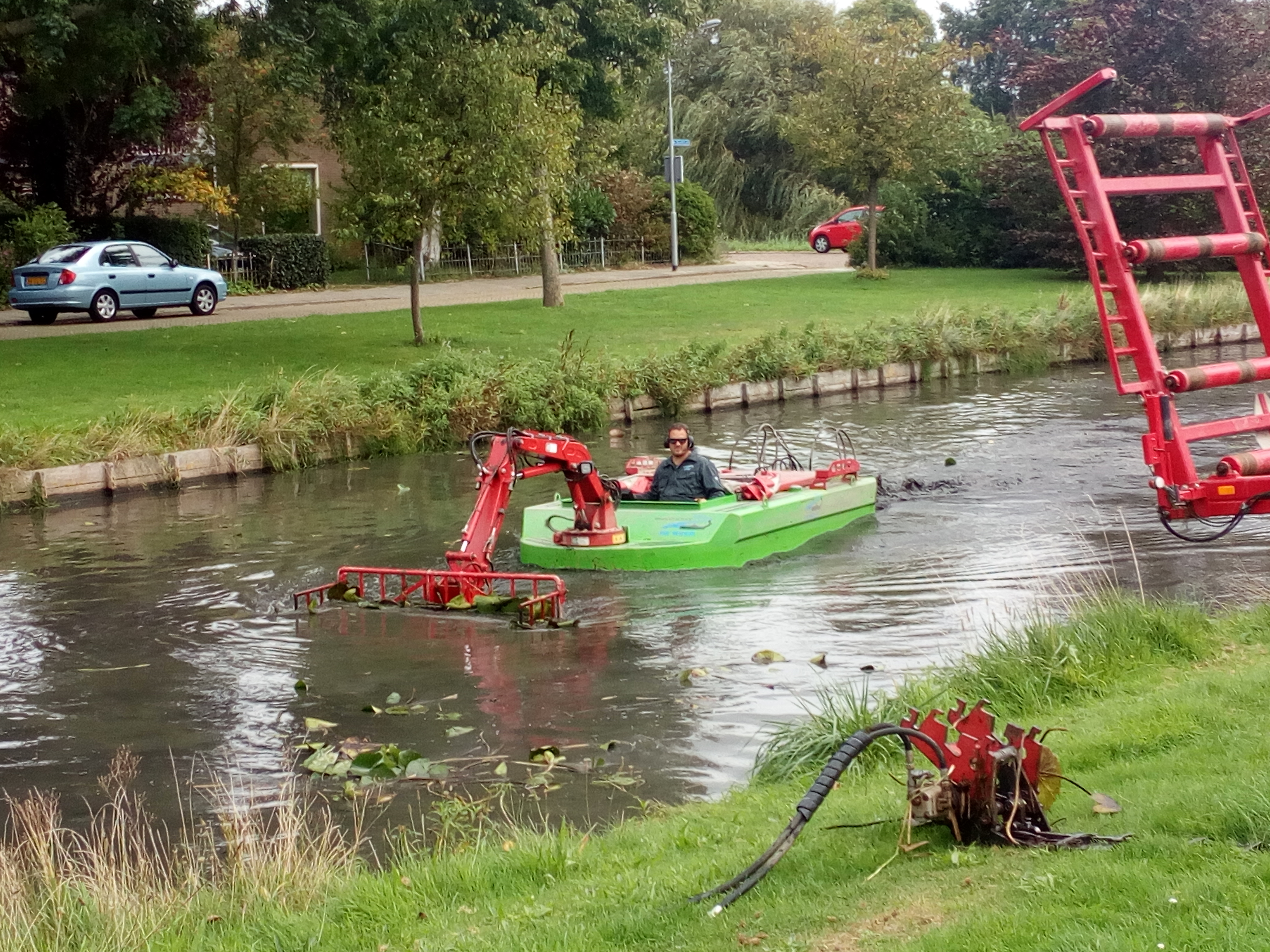 Met behulp van een speciaal voertuig worden waterplanten in de sloot aan de Zaalberglaan gemaaid. (Foto: Leo Tillmans)
