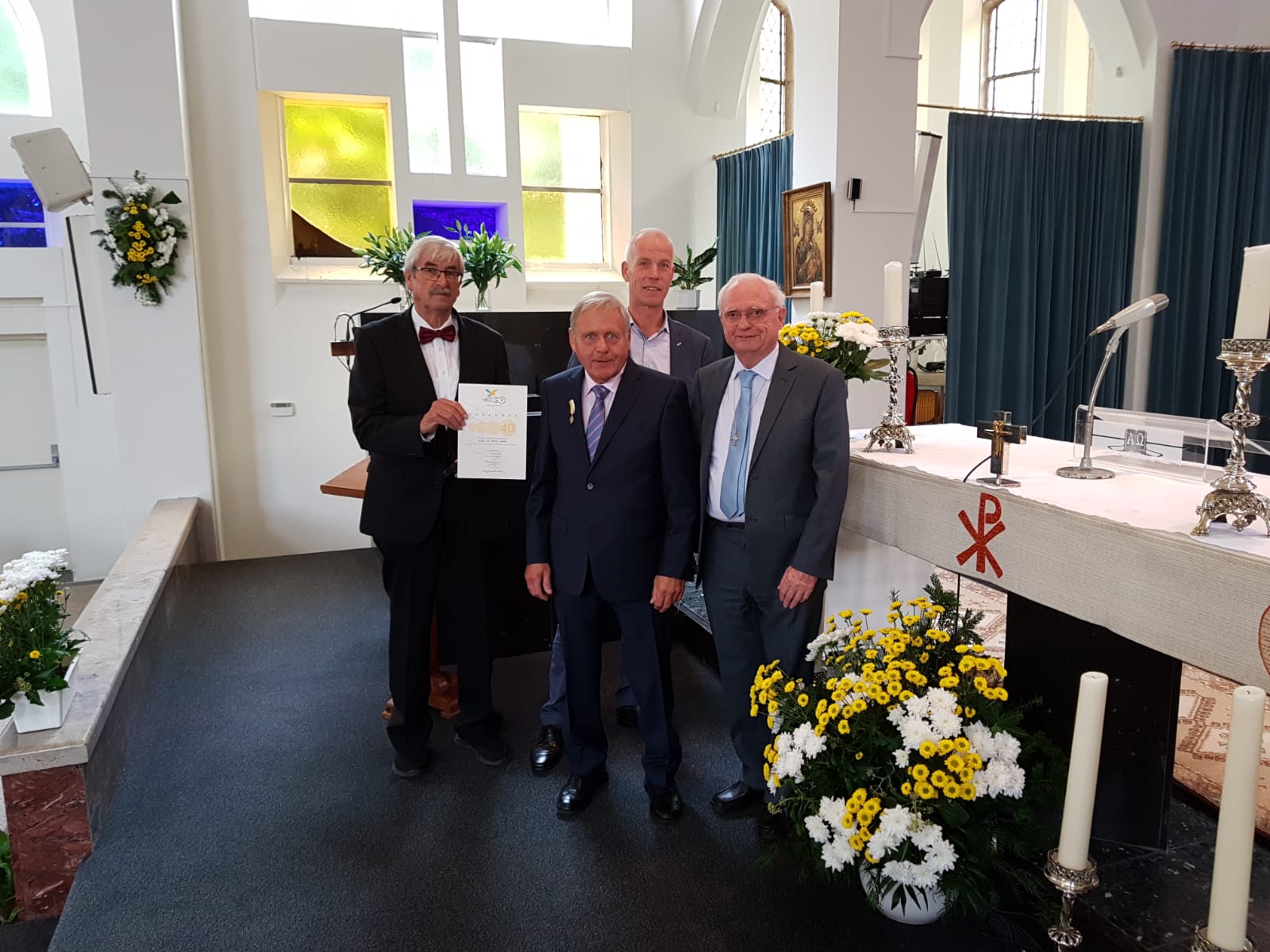 Vlnr. Hans Munster (voorzitter gemengd koor), jubilaris Luc Niekus, Johan Zwemmer (voorzitter parochierad) en jubilaris pastor Henny Slot. (aangeleverde foto)